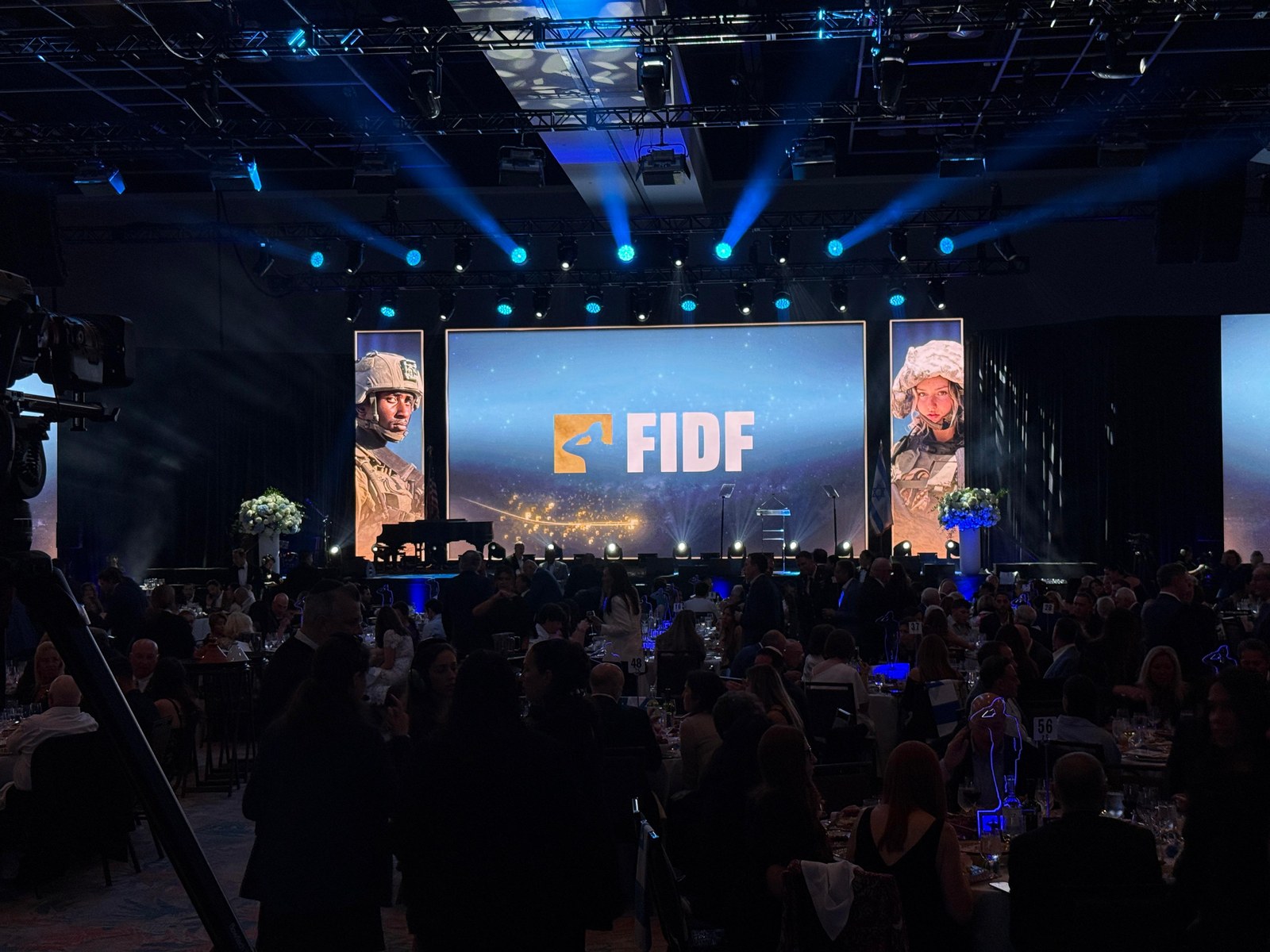 FIDF gala main screen and flanking portrait panels above a full banquet hall
