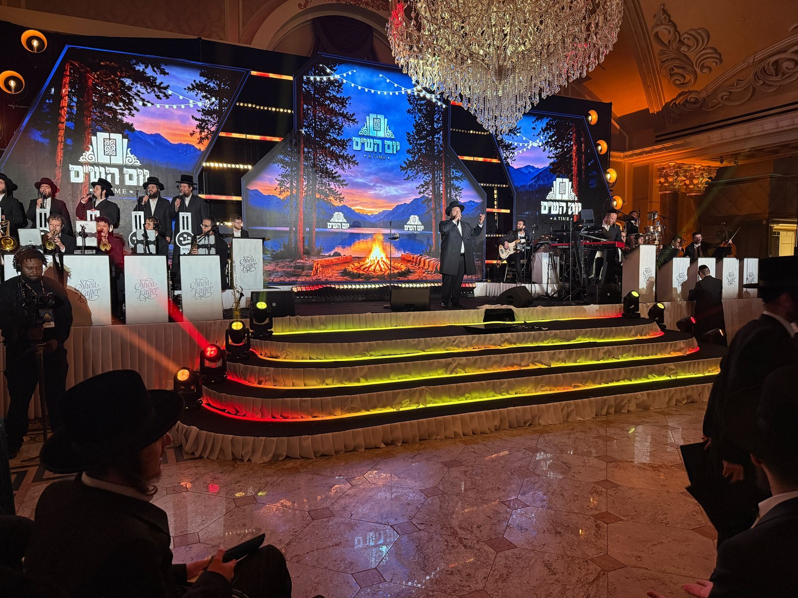 The same stage geometry showing a mountain lake and campfire scene at dusk