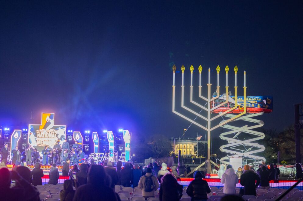 National Menorah stage identity and scenic design illuminated at night near the White House